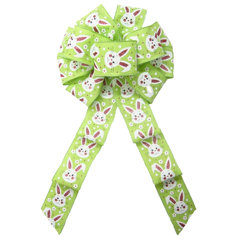 May include: A green and white ribbon bow with a bunny rabbit pattern. The bow is tied with a loop and tails.