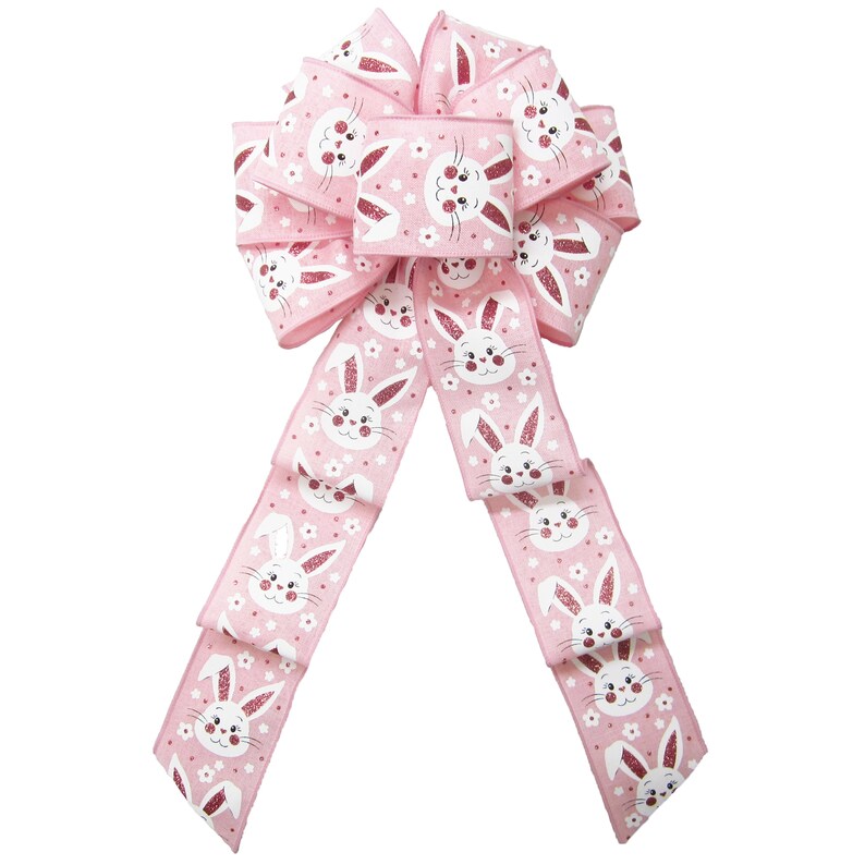 May include: A pink Easter bow with a white bunny rabbit pattern. The bow has a large center loop and two long tails.