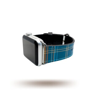Könnte beinhalten: Eine silberne Apple Watch mit einem blauen und gelben karierten Armband.