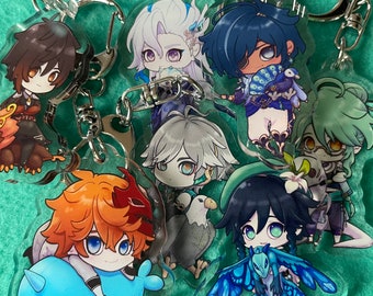 Może przedstawiać: Zestaw 8 kolorowych breloków z postaciami z anime. Postacie są narysowane w stylu chibi i mają różne kolory, fryzury i stroje. Breloki są wykonane z przezroczystego akrylu i mają metalowe kółka do przypięcia do kluczy lub toreb.