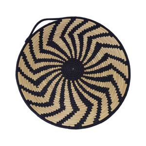 May include: Circular woven basket featuring a black and natural zig-zag design. The basket has a black central area and a black handle. It is made from natural fibres.
