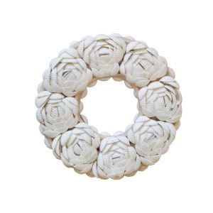 Peut inclure: Une couronne de coquillages blancs, faite de nombreuses petites coquilles, disposées en forme circulaire.