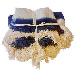 May include: A blue and cream striped throw blanket with fringe. The blanket is tied with a white ribbon that says "My Bliss Home".