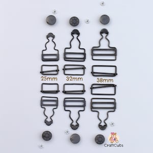 May include: Three sets of black metal clasps with different sizes: 25mm, 32mm, and 38mm. Each set includes a top and bottom piece. The clasps are designed for attaching garments or other items.