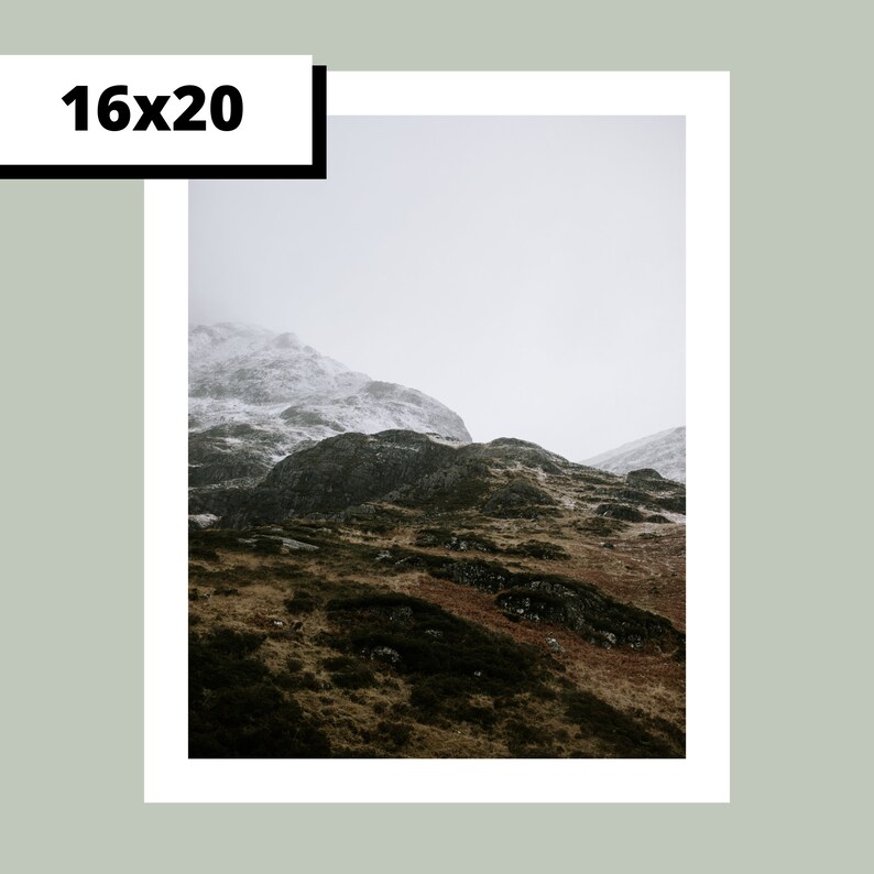 May include: A misty mountain landscape with snow-capped peaks and rolling green hills. The scene is captured in a muted color palette, creating a sense of tranquility and solitude.