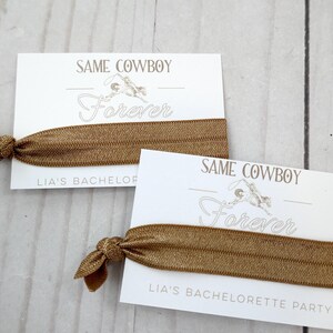 K&ouml;nnte beinhalten: Zwei wei&szlig;e Karten mit dem Text "Same Cowboy Forever" und einem braunen Gummiband. Die Karten sind f&uuml;r eine Junggesellinnenparty.