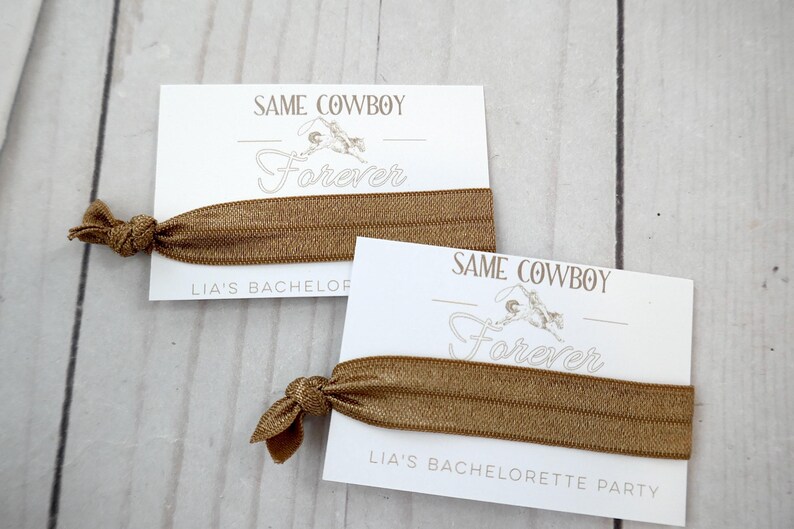 K&ouml;nnte beinhalten: Zwei wei&szlig;e Karten mit dem Text "Same Cowboy Forever" und einem braunen Gummiband. Die Karten sind f&uuml;r eine Junggesellinnenparty.