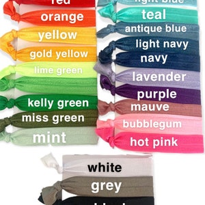 May include: A set of 18 colorful hair ties in various shades of red, orange, yellow, green, blue, purple, pink, and white. The hair ties are arranged in rows with the color name printed below each one.