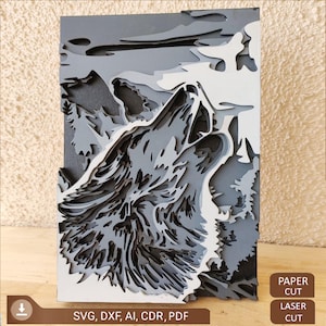 May include: A layered paper cut design of a wolf howling at the moon. The wolf is in shades of grey and white, and the background is a dark grey with a white sky. The image is labelled "Paper Cut" and "Laser Cut" in the bottom right corner.