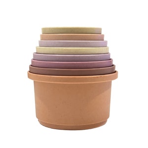Könnte beinhalten: Ein Satz von sechs ineinander verschachtelten Schalen in verschiedenen Brauntönen, Rosa und Beige. Die Schalen sind aus einem strukturierten Material gefertigt und eignen sich perfekt zum Stapeln und Spielen.