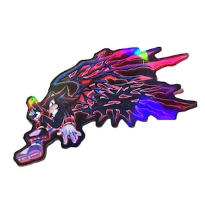 May include: Holographic sticker depicting a character in black and red, in a dynamic pose. The sticker has a jagged, wing-like shape and an iridescent finish, reflecting multiple colours. A vibrant collectible.