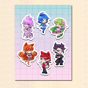 May include: A sheet of stickers featuring six anime-style characters with vibrant colors. The characters have unique hairstyles and outfits, with a mix of pink, blue, green, orange, and purple hues. The text "Welcome! Demon School! Iruma-kun" is also visible.