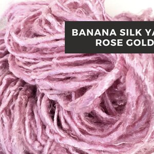 Puede incluir: Primer plano de una madeja de hilo de seda de pl&aacute;tano de color oro rosa. El hilo es suave y delicado, con un brillo sutil.