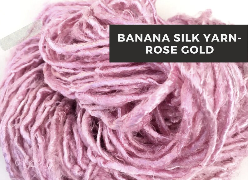 Puede incluir: Primer plano de una madeja de hilo de seda de pl&aacute;tano de color oro rosa. El hilo es suave y delicado, con un brillo sutil.