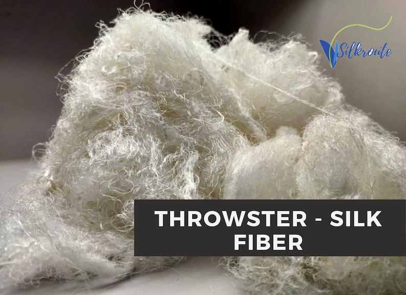 White throwster silk fiber in a loose pile, showing soft irregular silk strands and natural texture.