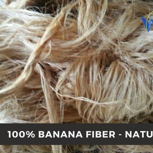 Close view of natural beige banana fiber bundles with visible long strands and soft twists.