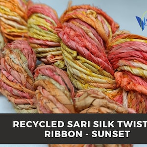 Puede incluir: Primer plano de un manojo de cinta retorcida de seda sari reciclada en tonos naranja, amarillo y rosa. La cinta es suave y texturizada, con un brillo sutil. El texto "RECYCLED SARI SILK TWISTED RIBBON - SUNSET" es visible en la parte inferior de la imagen.