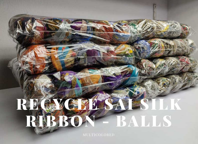 Stacked clear packs of multicolored recycled sari silk ribbon balls