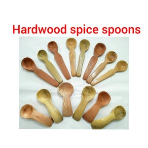 May include: A set of 14 wooden spoons, made from hardwood, in various shades of brown. The spoons are arranged in a semi-circle, with the handles pointing outwards. The spoons are all roughly the same size and shape, and they have a smooth, polished finish.