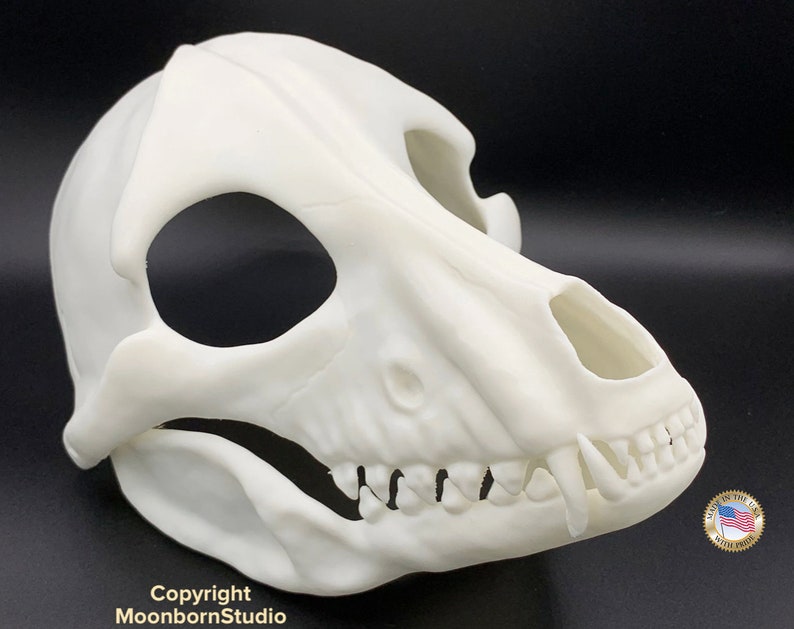K&ouml;nnte beinhalten: Wei&szlig;e Plastik-Sch&auml;delmaske mit detaillierten Z&auml;hnen und Augenh&ouml;hlen. Die Maske ist so konzipiert, dass sie einem Sch&auml;del eines Hundes &auml;hnelt.