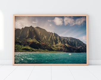 May include: A scenic photograph of a lush green mountain range with rocky cliffs, overlooking a turquoise ocean with a small white boat in the distance. The sky is a bright blue with fluffy white clouds.