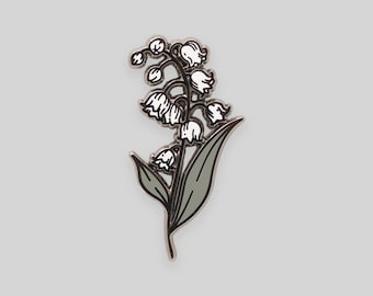 May include: A silver enamel pin featuring a white lily of the valley flower with green leaves.