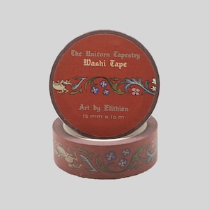 May include: A roll of terracotta-colored washi tape featuring a repeating pattern of a unicorn and floral vines. The label reads The Unicorn Tapestry Washi Tape, Art by Elithien, 15 mm x 10 m. The tape has a matte finish with detailed illustrations.