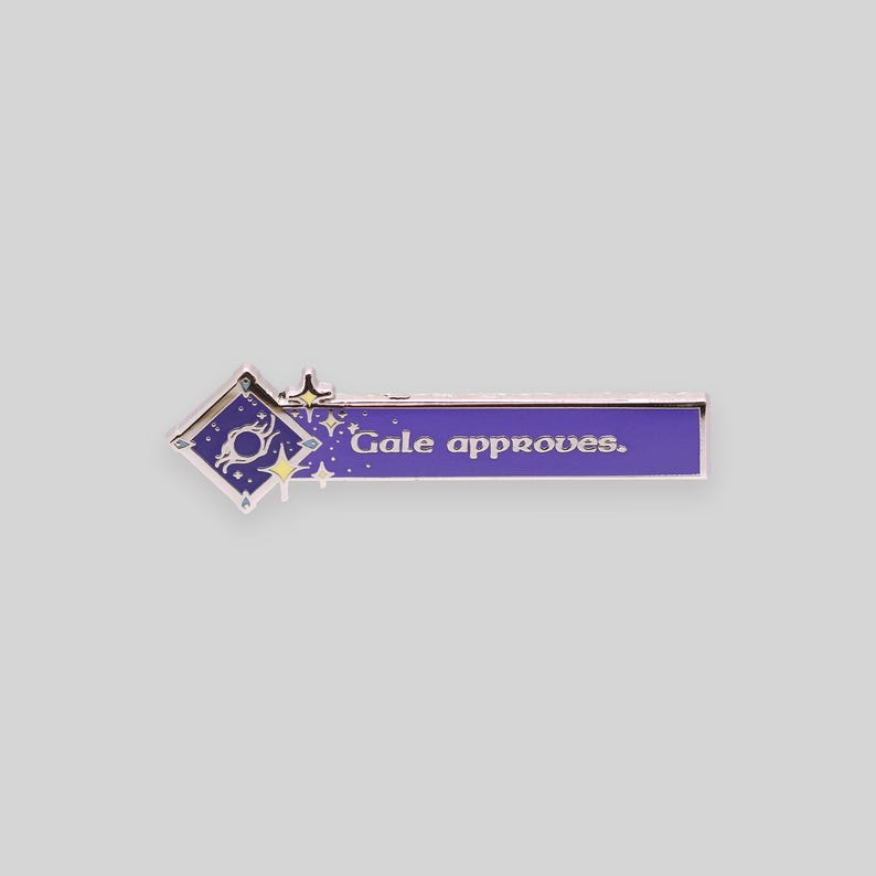 May include: Purple enamel pin with a silver border. The pin features a stylized star with a circle inside and the text "Gale approves."