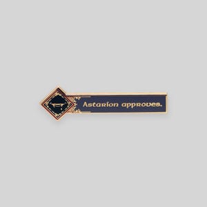 May include: Gold-colored enamel pin with a dark blue background and gold lettering. The pin features a stylized image of a coffin with a crown and the text "Astarion approves."