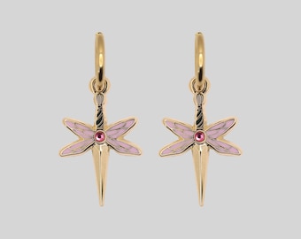 May include: A pair of gold hoop earrings featuring a dangling charm shaped like a dragonfly with light pink enamel wings and a small, round, dark pink gemstone set in the center of the body, suspended from a simple gold circular hoop.