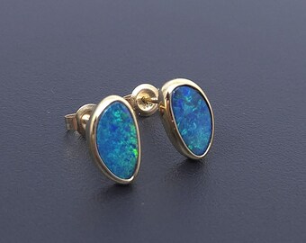 Puede incluir: Un par de pendientes de botón de oro con piedras de ópalo azul de forma ovalada.