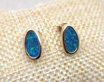 Puede incluir: Un par de pendientes ovalados de oro con piedras preciosas de ópalo azul.