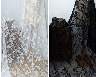 May include: Two pieces of floral lace fabric, one white and one black. The lace has a delicate floral pattern and a scalloped edge.