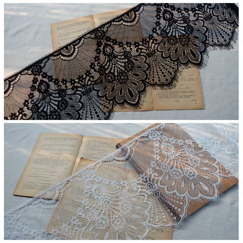 May include: Two pieces of black and white lace trim with scalloped edges. The lace is delicate and intricate with a floral pattern.