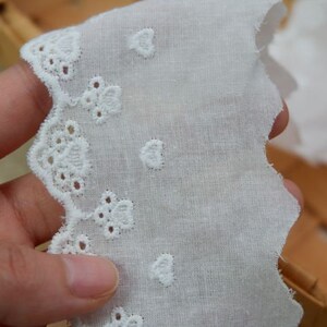 Peut inclure: Bordure en dentelle de coton blanche avec un bord festonn&eacute; et une broderie florale d&eacute;licate.