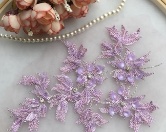 Puede incluir: Un conjunto de tres aplicaciones florales de color lavanda con lentejuelas y cuentas. Las aplicaciones son perfectas para añadir un toque de elegancia a cualquier proyecto.