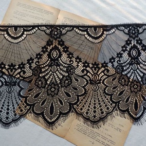 May include: Black lace trim with a delicate floral pattern. The lace has a scalloped edge and is perfect for adding a touch of elegance to any project.