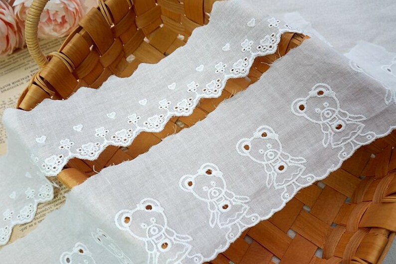 Peut inclure: Galon de dentelle en coton blanc avec un bord festonn&eacute; et des motifs d'ours en peluche brod&eacute;s. La dentelle est parfaite pour ajouter une touche d'&eacute;l&eacute;gance &agrave; tout projet.