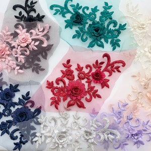 Puede incluir: Surtido de apliques de encaje floral en varios colores, incluyendo rosa, azul, rojo, blanco y morado. Cada aplique presenta delicados diseños florales con acentos de flores en 3D.