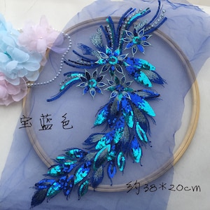 May include: Blue and teal sequined applique with a floral design. The applique is approximately 38 inches by 20 inches.