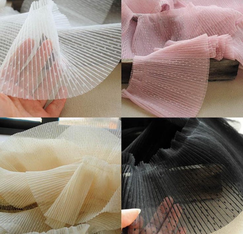 May include: Four samples of pleated fabric with polka dots. The fabric is white, pink, beige, and black.