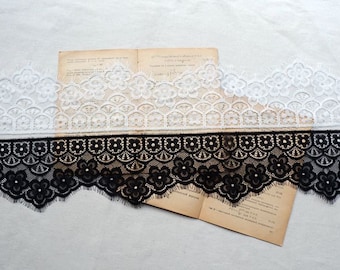 May include: Two pieces of lace trim, one white and one black. Both trims have a scalloped edge and a floral design.