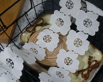May include: White lace trim with a floral design. The lace is in a basket with a wooden base and a brown bow.