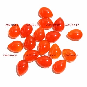 May include: A collection of 14 orange carnelian gemstone teardrop cabochons. The stones are smooth and polished, with a deep orange colour.