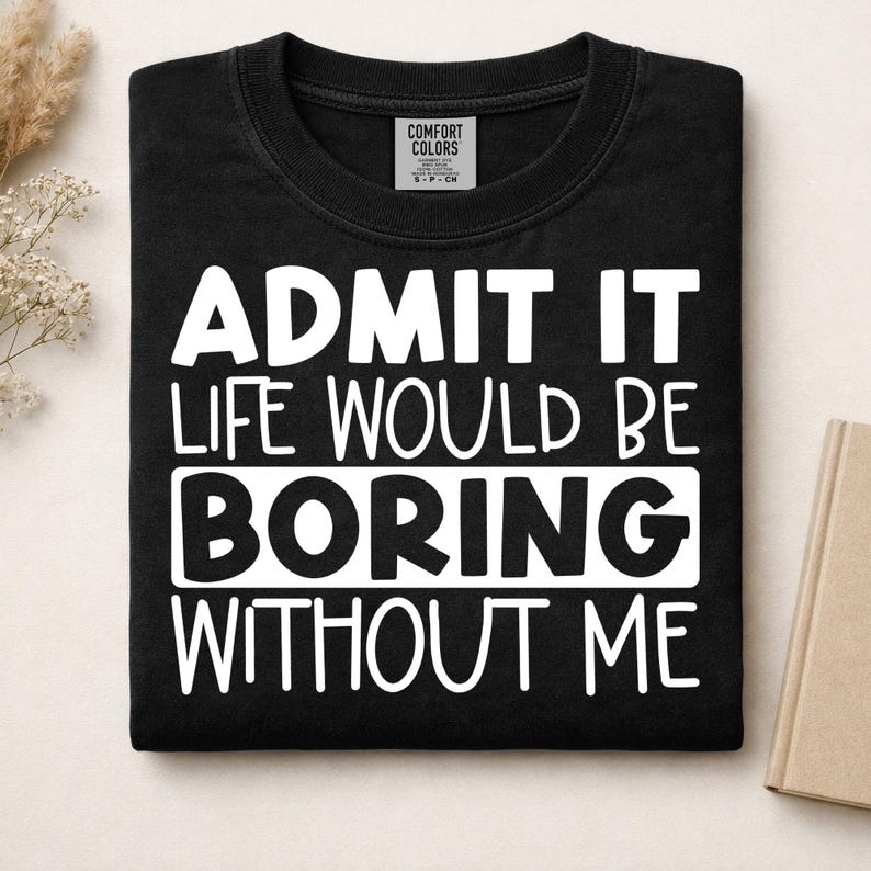 May include: A black short-sleeved t-shirt with a white graphic print that reads ADMIT IT LIFE WOULD BE BORING WITHOUT ME. The shirt features a Comfort Colors brand label at the inner neckline, indicating a size small, and is made of cotton.