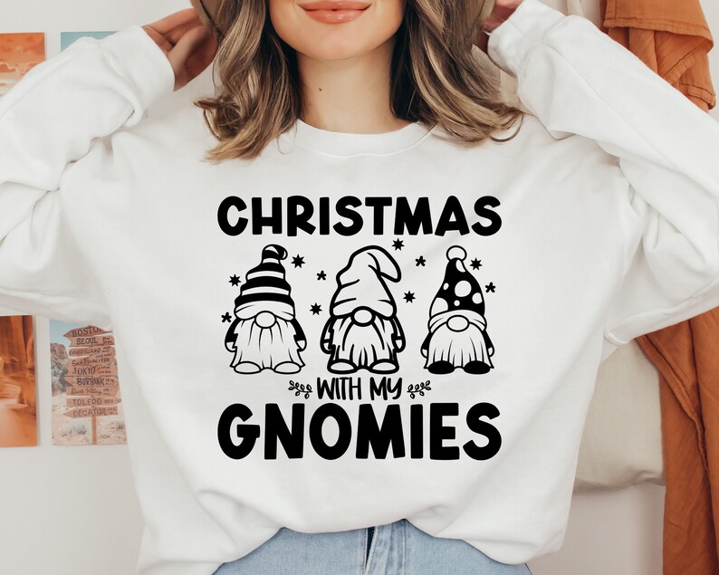 May include: White sweatshirt with black text that reads "Christmas with my Gnomies" and three black and white gnome illustrations.