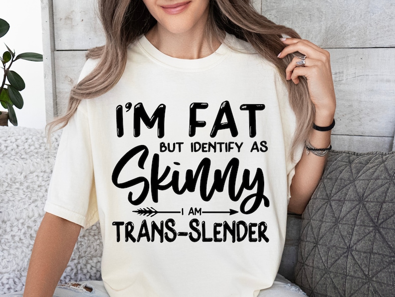 May include: White t-shirt with black text that reads "I'm fat but identify as skinny I am trans-slender".