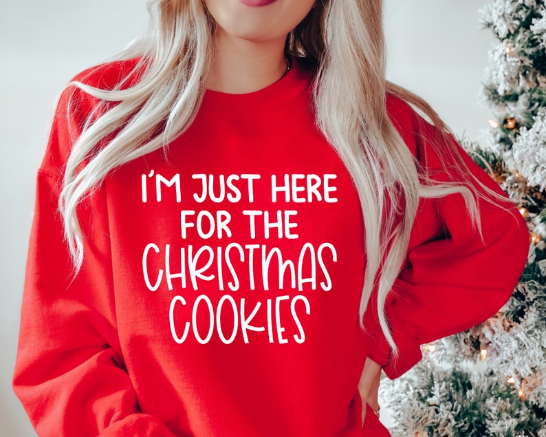 Peut inclure: Sweat-shirt rouge de No&euml;l avec un texte blanc qui dit "Je suis juste l&agrave; pour les biscuits de No&euml;l".