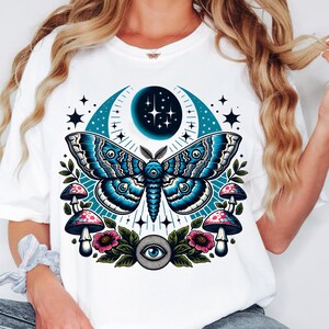 May include: White t-shirt with a blue and black moth, crescent moon, stars, mushrooms, and a single eye graphic.