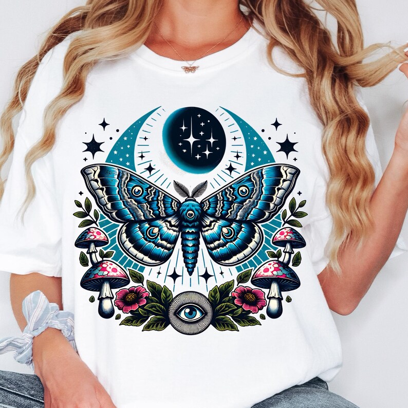 May include: White t-shirt with a blue and black moth, crescent moon, stars, mushrooms, and a single eye graphic.